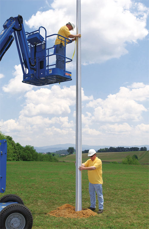 2 men mounting an direct buried light pole