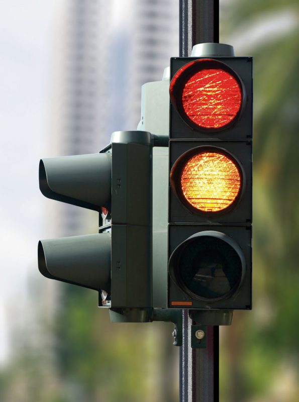 Picture of a black traffic light with red and yellow lights